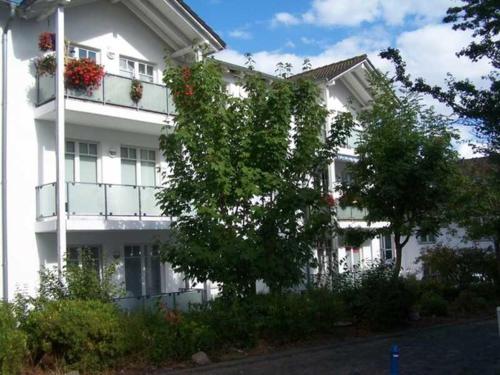 奥斯特巴德·哥伦Appartement Granitz - Ferienwohnung Thoenissen的白色的建筑,阳台上放着花盒