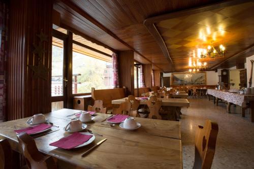 瓦勒迪泽尔科莱特酒店的餐厅设有木桌、椅子和大窗户。