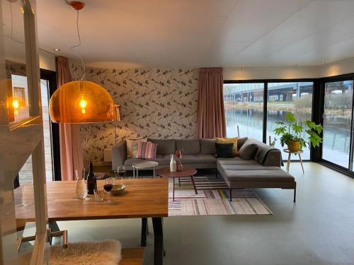鹿特丹Unieke woonark met privétuin en free parking.的客厅配有沙发和桌子