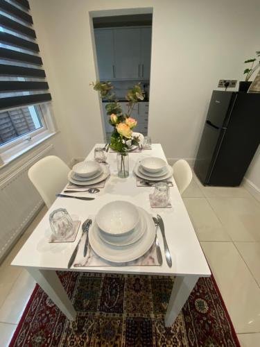 滨海绍森德B&T Pleasure Homes - Southend的一张带盘子和餐具的白色桌子