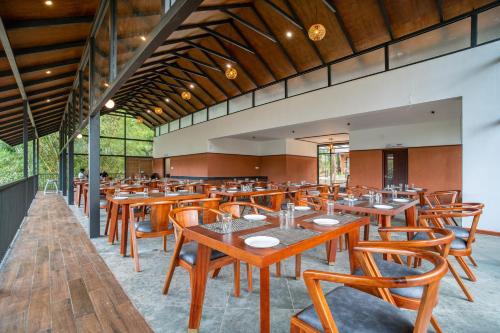 瓦亚纳德Crystal Kuruva Nature Resort & Spa的用餐室配有木桌和椅子