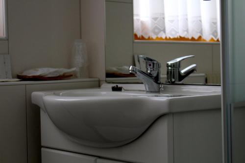 因斯布鲁克盖斯特夫奥尔伯格酒店的浴室设有白色水槽和镜子