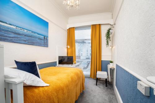 斯卡伯勒Glenholme Guest House - Room Only的酒店客房设有一张黄色的床和窗户。