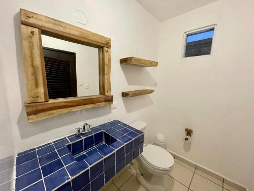 图卢姆MIO Tulum Hotel Boutique的浴室设有卫生间、镜子和蓝色瓷砖