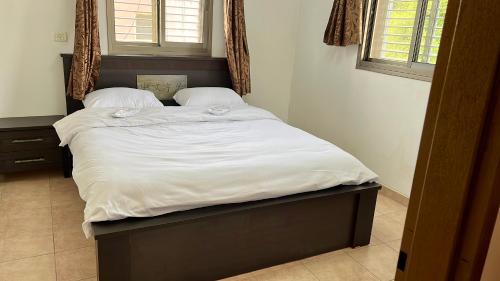 Dāliyat el KarmilVilla in village的一张配有白色床单和枕头的大床