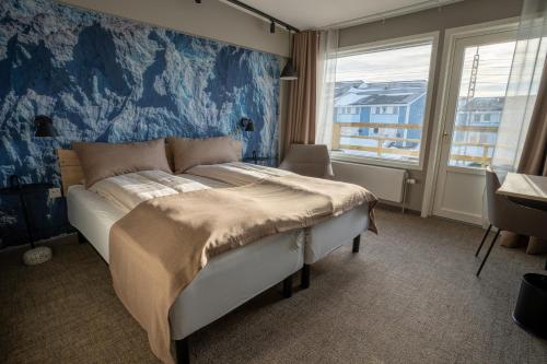 伊卢利萨特Hotel Hvide Falk的一间卧室配有一张蓝色墙壁的床