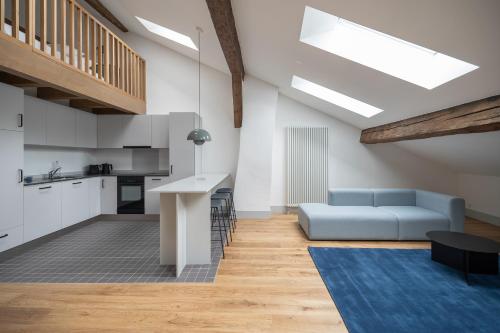 弗里堡La Sauvage的一间带蓝色沙发的客厅和一间厨房