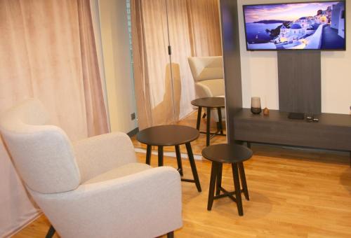 华沙Falcon Apartment Center 2 Metro Złote Tarasy的客厅配有桌椅和平面电视。