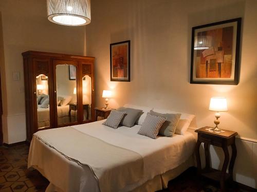 AgreloPosada Finca Garciarena的一间卧室配有一张带两盏灯和镜子的床