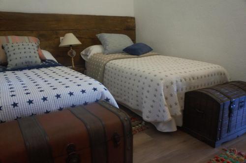 阿尔武希耶斯Amazing 4-Bed Cottage lost in Montseny Nature的一间卧室配有两张床和行李箱