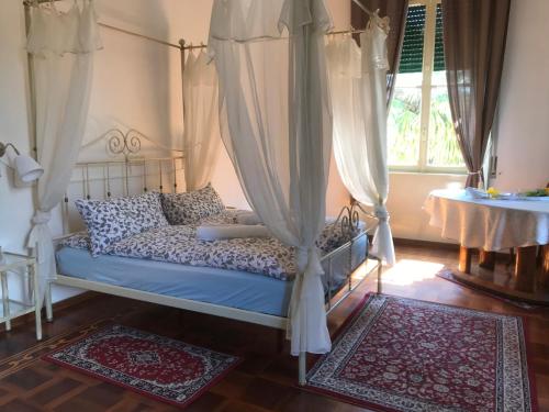 莱科天鹅别墅旅馆的一间卧室配有一张带窗帘和桌子的床