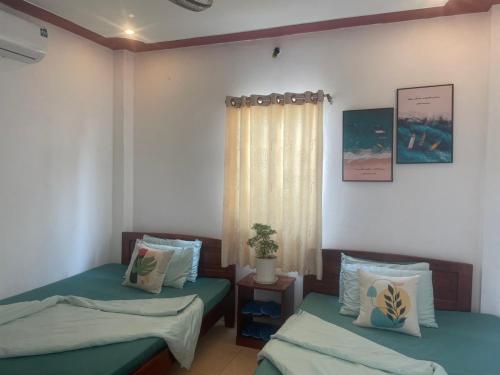 富国Nhà nghỉ Phương Dung的一间卧室设有两张床和窗户。