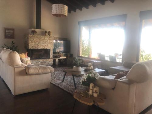 莫格罗La Carrera, Mogro Cantabria的客厅配有2张白色沙发和壁炉