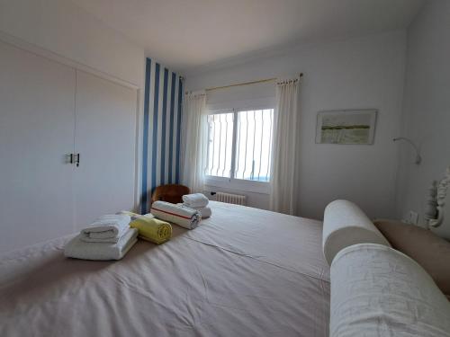 滨海托萨La Roqueta Hotel的卧室配有白色床和毛巾