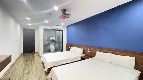 Dong Quan檀那穆酒店的一间设有两张床和蓝色墙壁的客房