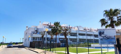 卡萨雷斯Casares Cozy Apartment的一座白色的建筑,前面有棕榈树