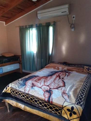 费德拉西翁Casa cabaña juanita的一间卧室配有一张带绘画的床铺