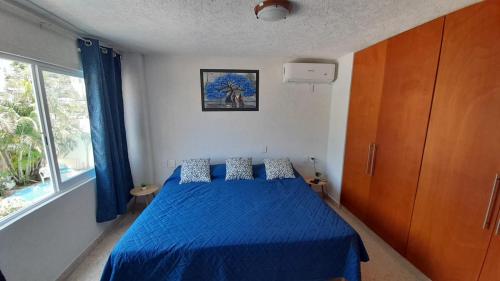 阿卡普尔科Hermoso Departamento Nuevo的一间卧室配有蓝色的床和蓝色的毯子