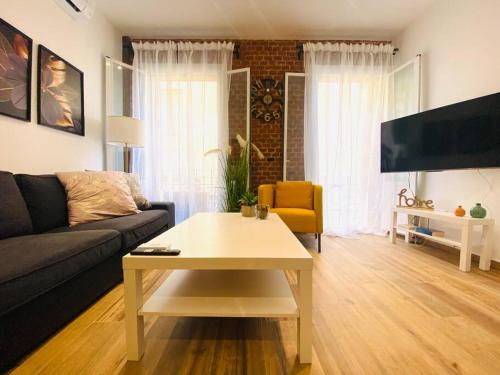 马德里Style & Design Flat in the Center of Madrid的带沙发和咖啡桌的客厅