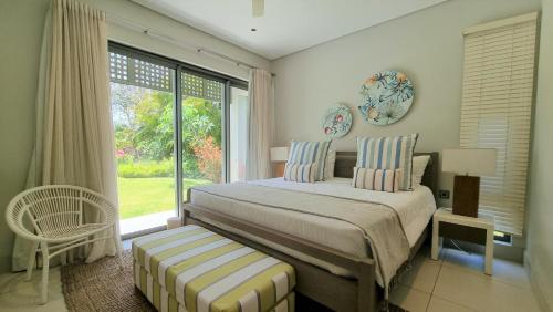 Beau ChampSuperior 4-Bedroom Villa at Anahita Golf & Spa Resort's的一间卧室设有一张床和一个大窗户
