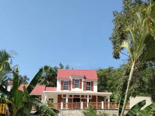 TancamaCasa la CEIBA的一座红色屋顶的房子,还有一些棕榈树