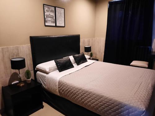 圣米格尔·德·图库玛Hotel La Terminal的一间卧室配有一张带黑色床头板的床
