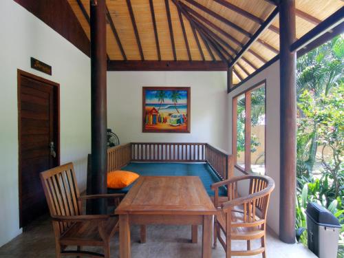 吉利特拉旺安Coconut Dream的一间带木桌和椅子的用餐室