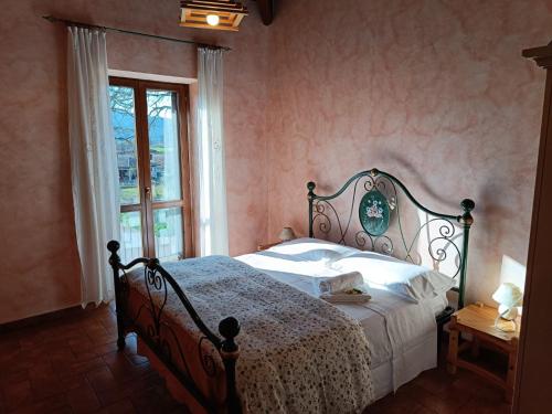 诺尔恰Agriturismo Le Case di Quarantotti的一间卧室配有一张带白色床单的床和一扇窗户。