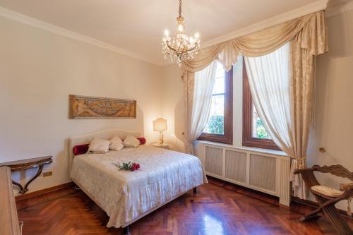 米拉Villa Liberty a soli 20km da Venezia的一间卧室配有一张床和一个吊灯