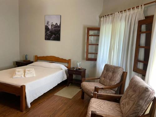 科洛尼亚西扎Hotel Suizo的一间卧室配有一张床和一把椅子