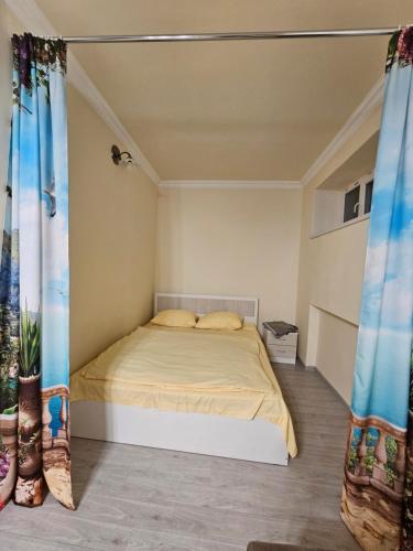 埃里温Sunny Apartment close to Erebuni mall的一间带床的卧室,位于带窗帘的房间