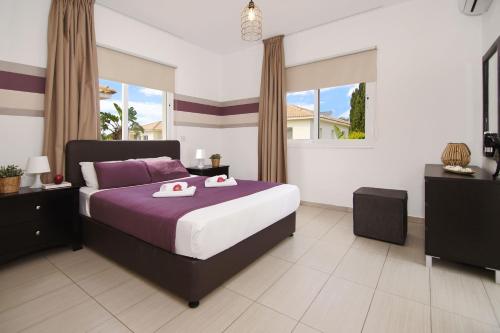 阿依纳帕Nissi Sapphire Villa的一间卧室配有一张床,上面有两条毛巾