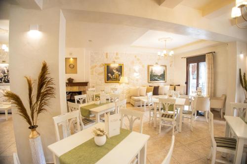 卡拉内拉阿格利斯酒店的一间带白色桌椅的餐厅和一间用餐室