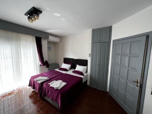 马尔马里斯安迪公寓酒店的一间卧室配有一张带紫色毯子的床