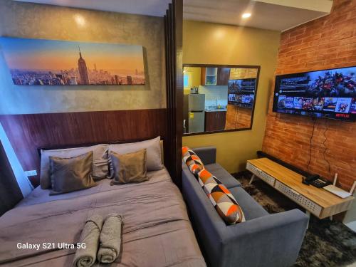 大雅台Luxurious Romantic Getaway in a stylish Condo的一间卧室配有一张床、一张沙发和一台电视。