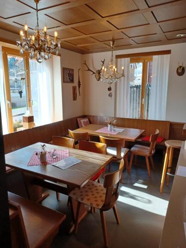 塞利斯贝格Hotel Tell的餐厅设有木桌、椅子和吊灯。