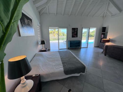 圣马丁岛Villa Taïana的一间卧室配有一张床和一张带台灯的桌子