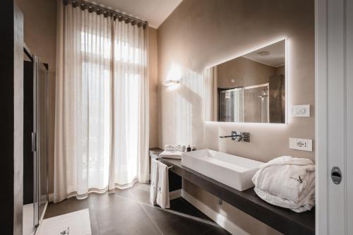 卡拉曼德拉纳Villa Adelaide Relais & Wine的一间带水槽和镜子的浴室