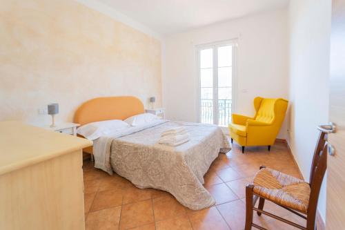 莫内利亚坡提可酒店的一间卧室配有一张床和一张黄色椅子