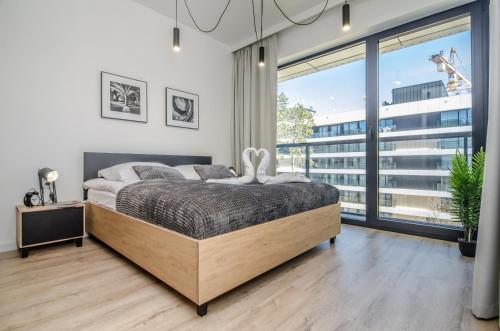 洛格沃Apartamenty Shellter Rogowo - ALL DAY HOLIDAY的一间卧室设有一张床和一个大窗户