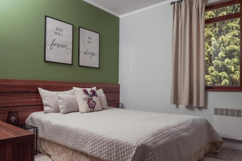 斯莫梁Утро без Аларма, Смолянски езера. Alarm free Morning Smolyan lakes的一间卧室设有一张带绿色墙壁和窗户的床。