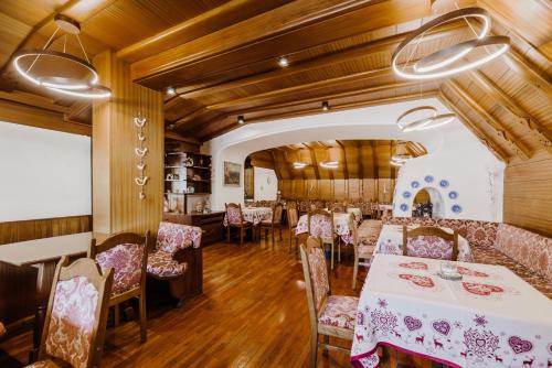 维哥迪法萨Hotel Rosa Wellness & SPA的用餐室设有桌椅和木制天花板