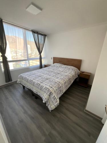 伊基克apartamento Lynch Costero Iquique的一间卧室设有一张床和一个大窗户