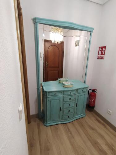 萨龙Apartamento de 120m2 al lado de Cabarceno的浴室设有蓝色梳妆台和镜子