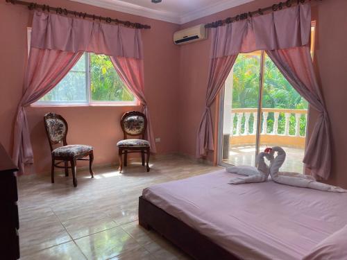 苏莎亚4 bedroom villa, security, private pool, ocean view的卧室配有2个天鹅床和窗户