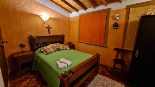 雷蒂罗Apartamento Acogedor en el Retiro的一间卧室配有一张带十字架的绿色床