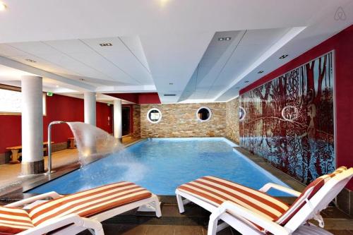 里苏尔RisoulSki Antarès - Piscine et Sauna的一个带两把椅子的房间的大型游泳池