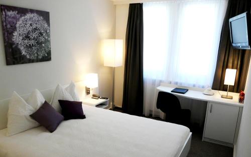 特湾Fontana Garni的一间酒店客房,配有一张白色的床和一张书桌