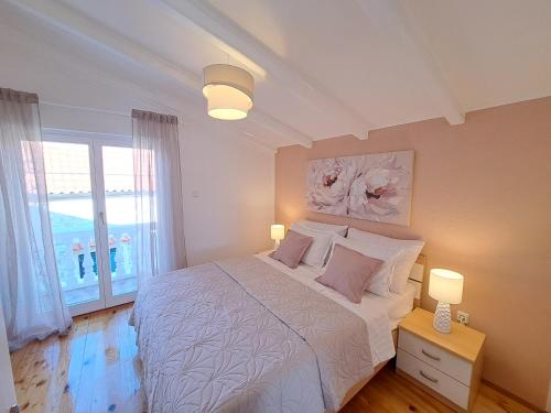 耶泽拉Apartments Nicole的一间卧室配有一张带两盏灯的床和一扇窗户。