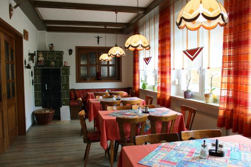 福恩施特劳斯祖姆施彻沃兹巴瑞酒店的一间设有桌椅的餐厅,位于带窗户的房间内